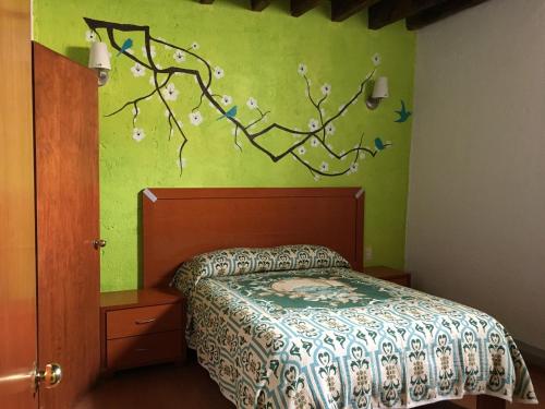 1 dormitorio con 1 cama y una rama en la pared en Hotel Terraza Castro en Zacatecas