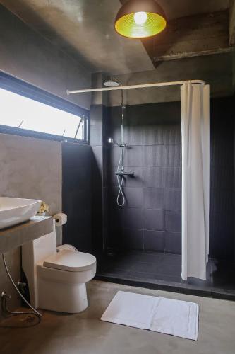 a bathroom with a shower and a toilet and a sink at Goodhope Villa in Sam Roi Yot