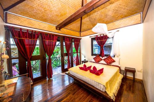 Un dormitorio con una cama con almohadas rojas. en Fruit Tree Lodge, en Ko Lanta