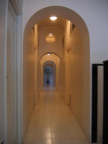 un corridoio vuoto con un arco in un edificio di Hotel Plaza (BOOKING FOR FOREIGN TOURIST ONLY) a Jālgaon