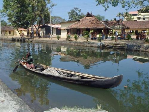 a person in a boat on the water at Nallathanka Nest Homestay in Kumarakom