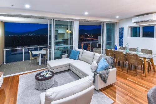 a living room with a white couch and a balcony at Empire Apartment Hotel Rockhampton in Rockhampton