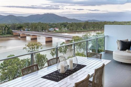 a balcony with a table and chairs and a view of a river at Empire Apartment Hotel Rockhampton in Rockhampton