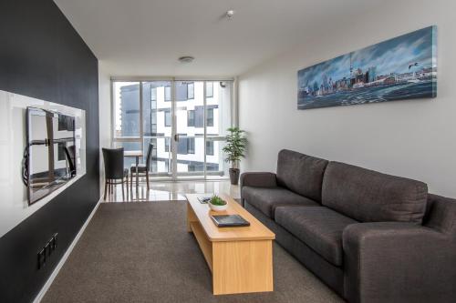 een woonkamer met een bank en een salontafel bij Crown on Cintra Lane in Auckland