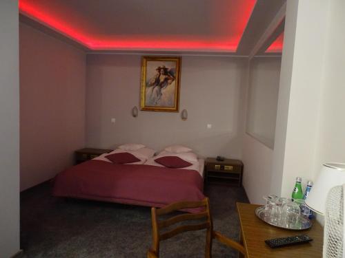 a bedroom with a bed with a red light on the ceiling at Motel 2000 in Stęszew