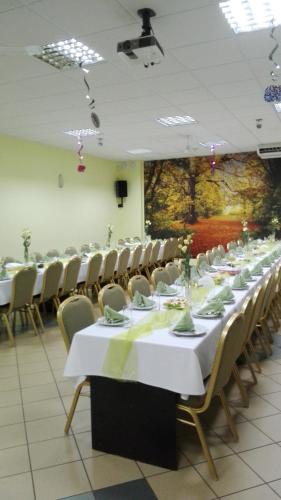 a long table with white tables and chairs in a room at HOTEL ODR in Sulechów
