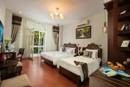 a hotel room with two beds and a table at Labevie Hotel in Hanoi