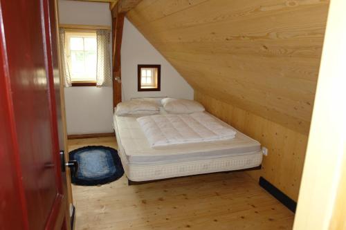 a small bedroom with a bed in the attic at Chata Hugo - 3 Retreat Apartments in Tanvald