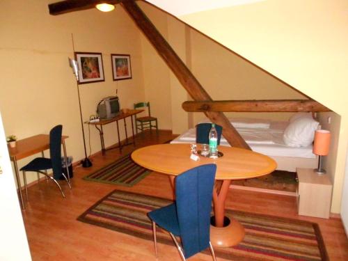 um pequeno quarto com uma mesa e uma cama em HAHNE s GÄSTEHAUS em Hanôver