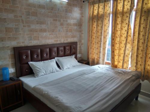 a bedroom with a large bed and a window at Shimla Facing Rooms Near Mall Road in Shimla
