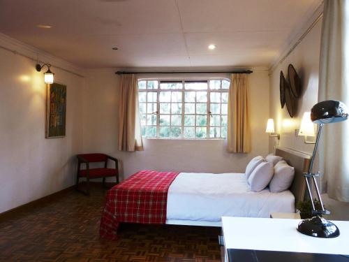 a hotel room with a bed and a window at Maison Mitwaba in Nairobi