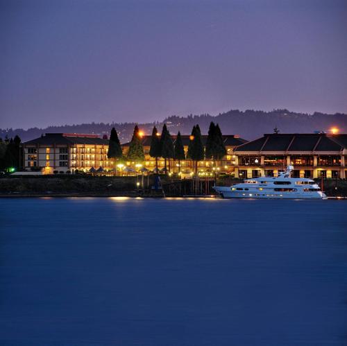 a boat in the water in front of buildings at night at Holiday Inn Portland - Columbia Riverfront by IHG in Portland