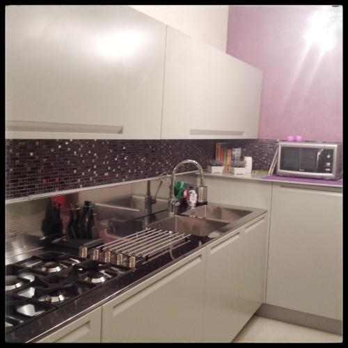 a kitchen with a sink and a stove top oven at Il riposo dei Giganti in Càbras
