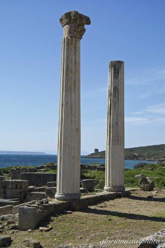two tall columns standing next to the ocean at Il riposo dei Giganti in Càbras