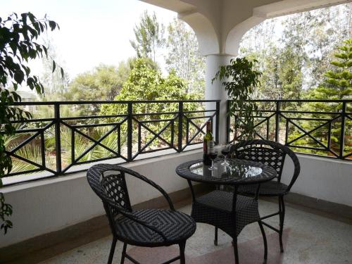 a table and two chairs on a balcony with a window at Maison Mitwaba in Nairobi
