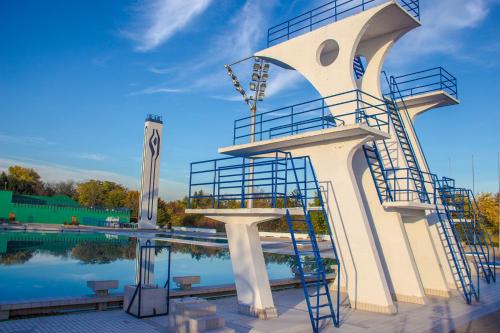 a building with a staircase next to a pool at Hostel Poolside Zagreb in Zagreb