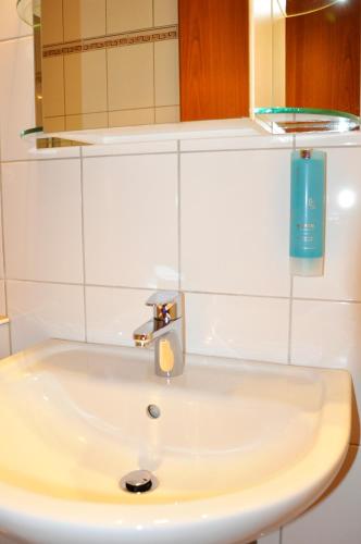 a bathroom sink with a faucet and a mirror at Hotel Atlantik in Borkum