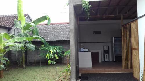 una puerta abierta de una casa con patio en Anugrah Jaya Guest House, en Canggu