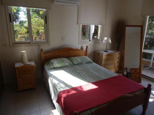 1 dormitorio con 1 cama grande y 2 ventanas en Byreva Apartments en Pafos