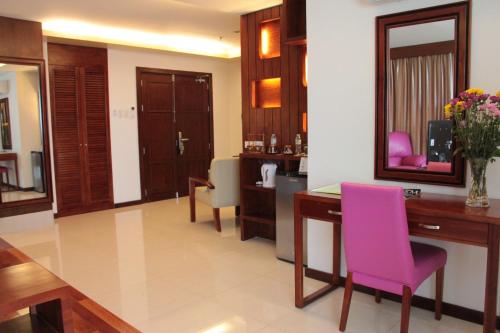 a living room with a desk and a pink chair at Skinetics Wellness Center Boutique Hotel in Iloilo City