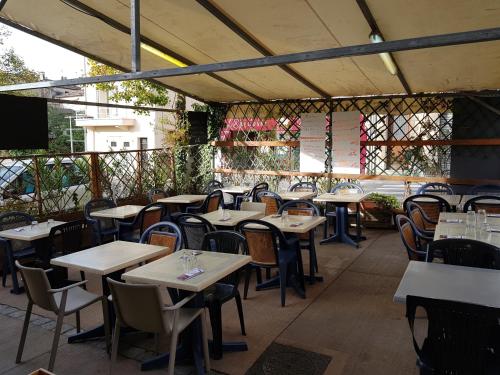 un ristorante vuoto con tavoli, sedie e schermo di Le Chemin Neuf a Gréoux-les-Bains