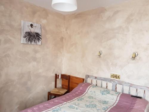 1 dormitorio con 1 cama y una foto en la pared en Le Chemin Neuf en Gréoux-les-Bains