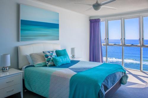 een slaapkamer met een bed met uitzicht op de oceaan bij Indigo Blue in Gold Coast