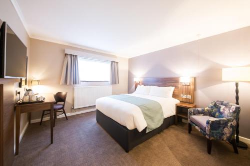 a hotel room with a bed and a desk and a chair at The Beach Arms by Innkeeper's Collection in Oakley