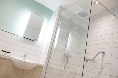 a bathroom with a sink and a glass shower at The Beach Arms by Innkeeper's Collection in Oakley