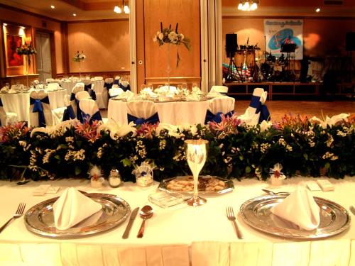 a table in a banquet hall with white table settings at Best Western Hotel Posada Del Rio Express in Torreón