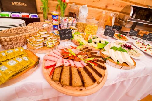 a table with many different types of food on it at Kurpiowska Kraina in Wydmusy