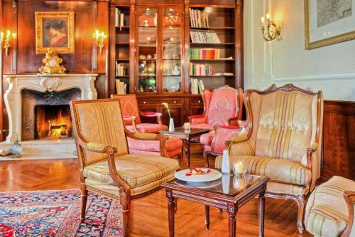 a living room with chairs and a table and a fireplace at SEETELHOTEL Ahlbecker Hof das elegante Traditionshotel & ruhiger Rückzugsort an der Ostsee in Ahlbeck