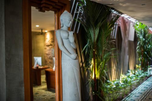 a statue of a woman standing in a room at Golden Temple Boutique in Siem Reap