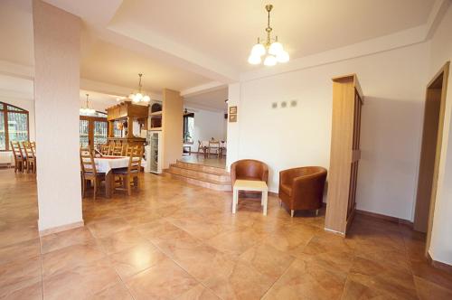 a dining room and living room with a table and chairs at Pensiunea Comarnic-Moisa in Comarnic