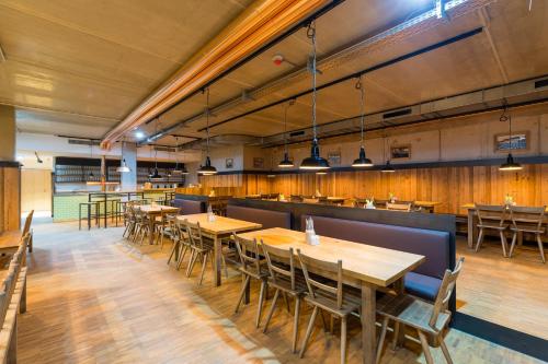 a dining room with wooden tables and chairs at mk | hotel rüsselsheim in Rüsselsheim