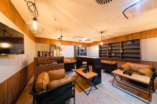 a large room with leather furniture and a piano at mk | hotel rüsselsheim in Rüsselsheim