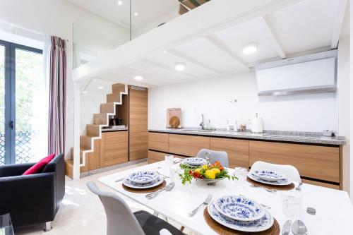a kitchen and dining room with a white table and chairs at Alohamundi Marqués de Paradas in Seville