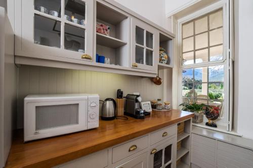 a kitchen with a counter with a microwave at Auberge Clermont in Franschhoek