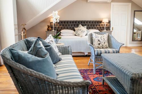 - une chambre avec un lit, des chaises et un canapé dans l'établissement Auberge Clermont, à Franschhoek