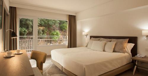 a bedroom with a large bed and a balcony at Bordoy Continental Valldemossa in Valldemossa