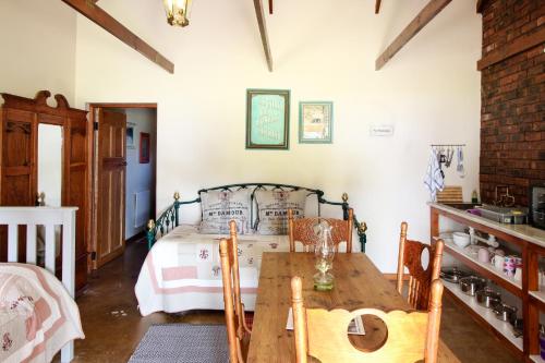 a bedroom with a bed and a wooden table at Lentelus Guesthouse in George