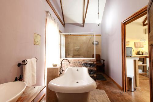 a bathroom with a bath tub and a sink at Lentelus Guesthouse in George