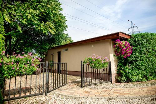 a fence with flowers on it next to a building at Royal Apartments Hotel Kecskemét in Kecskemét