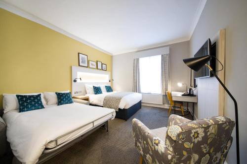 a hotel room with a bed and a couch at The Dun Cow by Innkeeper's Collection in Rugby