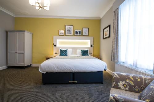 a bedroom with a large bed and a couch at The Dun Cow by Innkeeper's Collection in Rugby