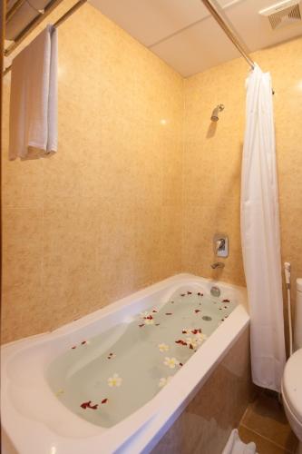 a bathroom with a bath tub with flowers on the floor at Parklane Hotel in Siem Reap