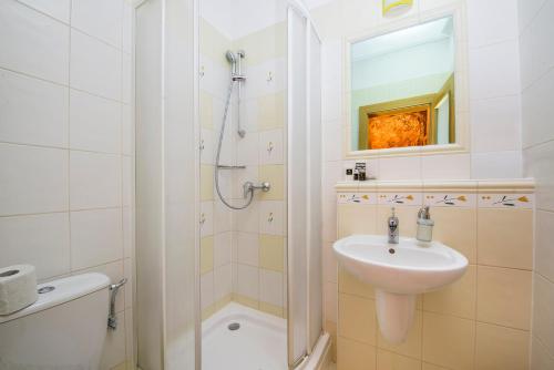 a white bathroom with a sink and a shower at Wellness Penzión Vila Mery in Poprad
