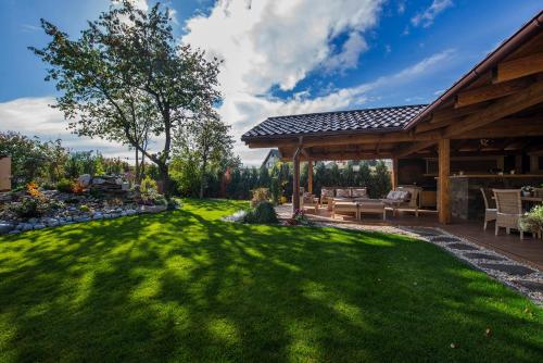 a backyard with a patio and a grass yard at Wellness Penzión Vila Mery in Poprad