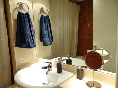 W łazience znajduje się umywalka, toaleta i lustro. w obiekcie My Holiday Home in Lisbon w Lizbonie