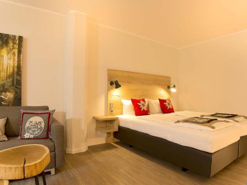 a hotel room with a bed and a chair at Elements Hotel Christlessee in Oberstdorf